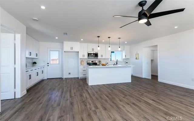 a view of kitchen with stainless steel appliances refrigerator stove microwave and cabinets