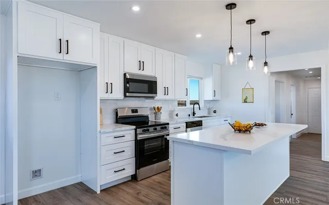 a kitchen with stainless steel appliances a stove a sink and a refrigerator