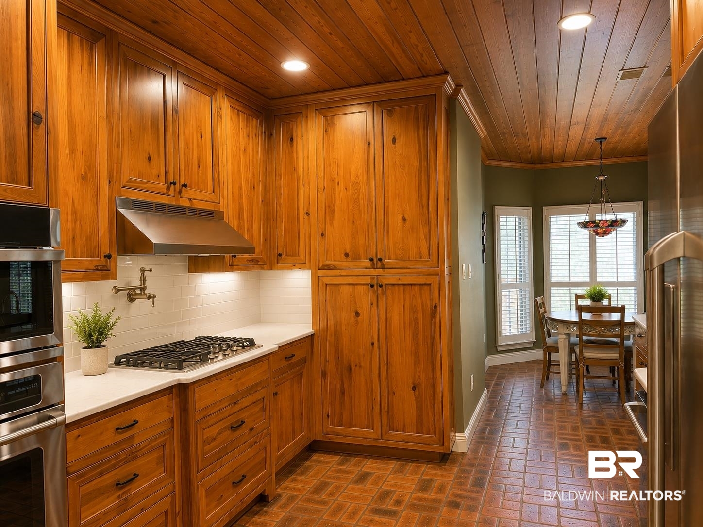 103 Raphael Semmes Drive East Spanish Fort, AL 36527 - Photo 4 of 9 Kitchen featuring wood-panel ceilings, extensive wood cabinetry, white subway tile backsplash, stainless steel range hood, and a built-in wall oven