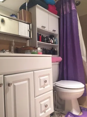 a bathroom with a toilet a sink and a window