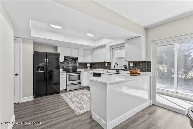 a kitchen with a sink cabinets stainless steel appliances and a window