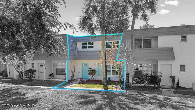 a view of a house with a yard and large tree