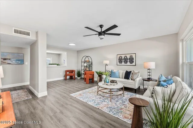 a living room with furniture and a wooden floor