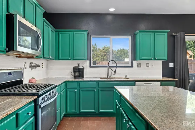 a kitchen with a sink stove top oven and cabinets