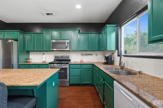 a kitchen with stainless steel appliances granite countertop a sink stove and refrigerator