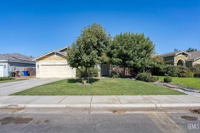 a front view of a house with a yard and a garage