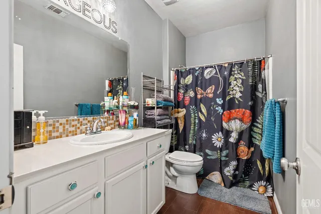 a bathroom with a sink vanity mirror and toilet