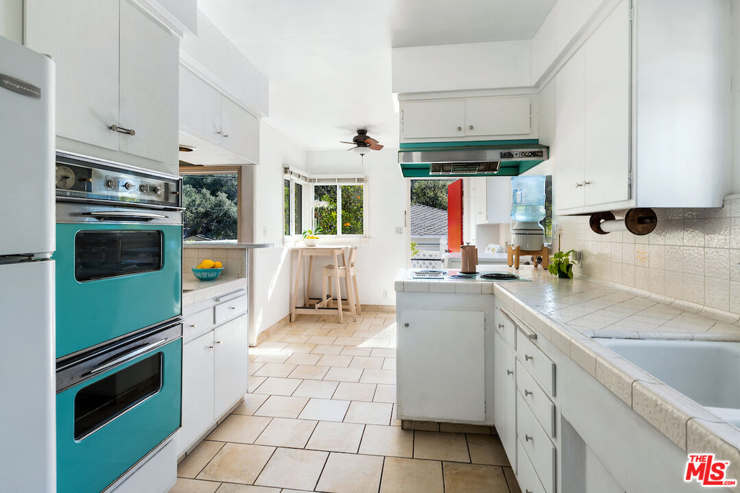 1856 Alpha Road Glendale, CA 91208 - Photo 12 of 32 a kitchen with stainless steel appliances a stove sink and cabinets