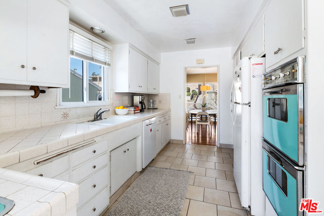 1856 Alpha Road Glendale, CA 91208 - Photo 13 of 32 a large white kitchen with cabinets