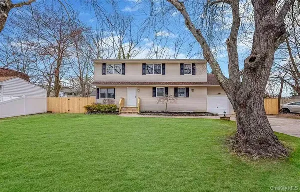 a view of a yard in front of a house with large tree