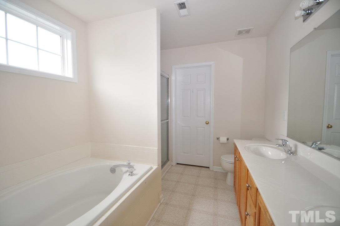 2529 Dality Drive Raleigh, NC 27604 - Photo 15 of 20 a bathroom with a tub sink and mirror