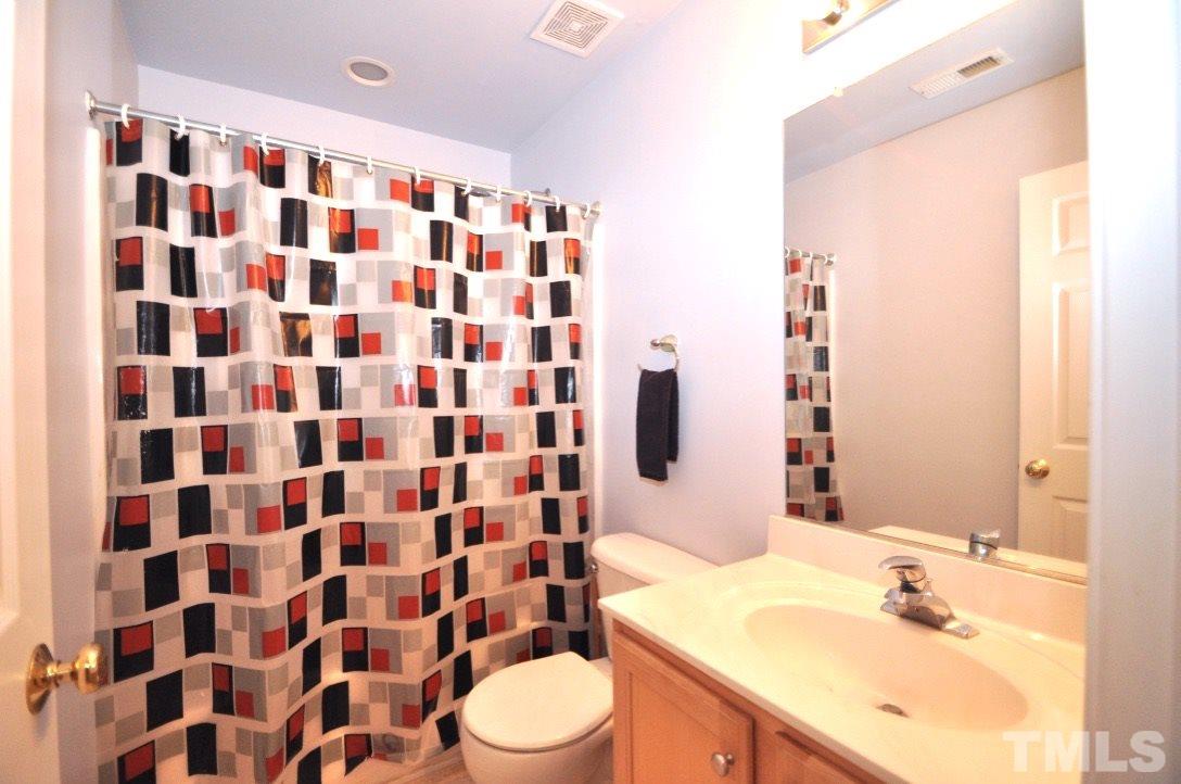 2529 Dality Drive Raleigh, NC 27604 - Photo 19 of 20 a bathroom with a sink a toilet a shower and a mirror