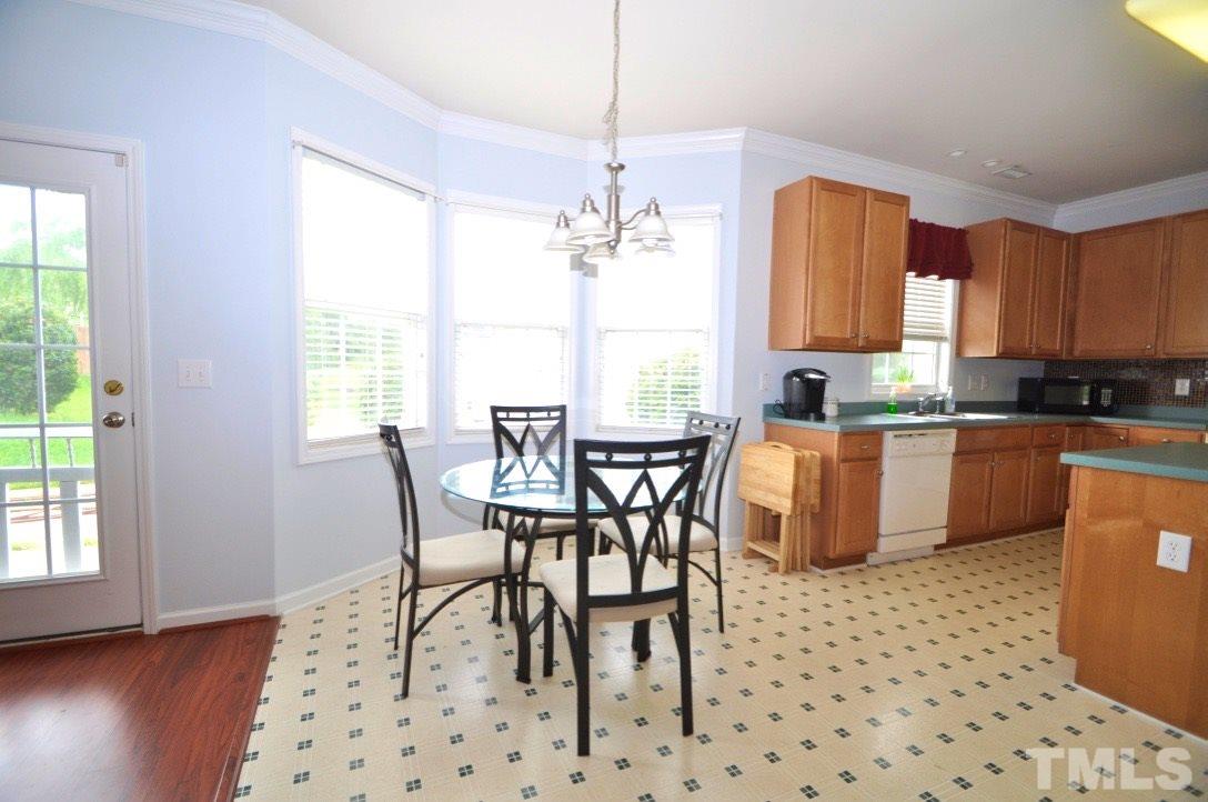 2529 Dality Drive Raleigh, NC 27604 - Photo 6 of 20 a kitchen with granite countertop a dining table chairs cabinets a sink and a window