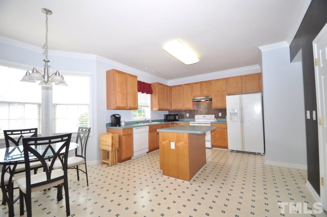 2529 Dality Drive Raleigh, NC 27604 - Photo 7 of 20 a kitchen with a refrigerator a dining table and chairs