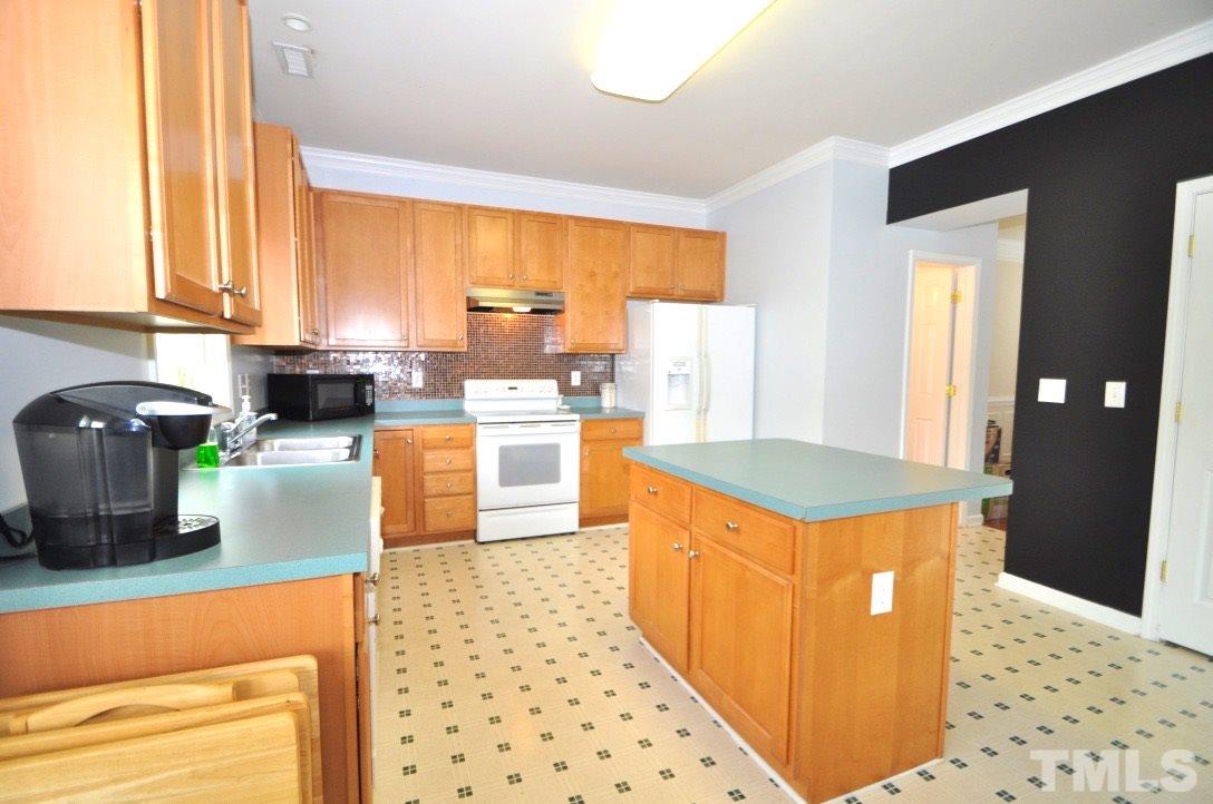 2529 Dality Drive Raleigh, NC 27604 - Photo 8 of 20 a kitchen with stainless steel appliances kitchen island granite countertop a stove a sink and a microwave
