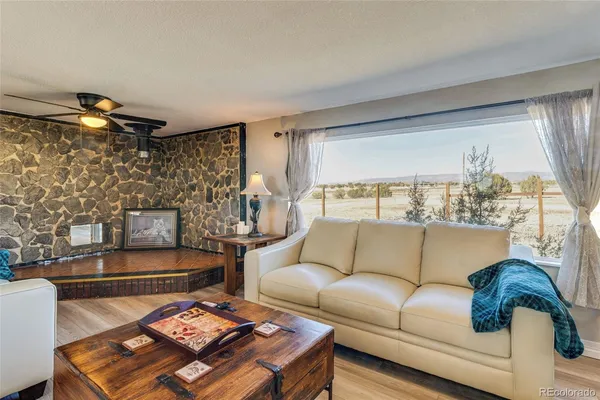 a living room with furniture and a floor to ceiling window