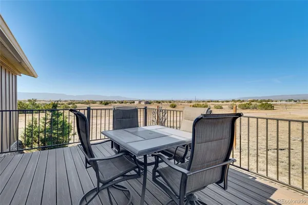 a view of a balcony with furniture and wooden floor