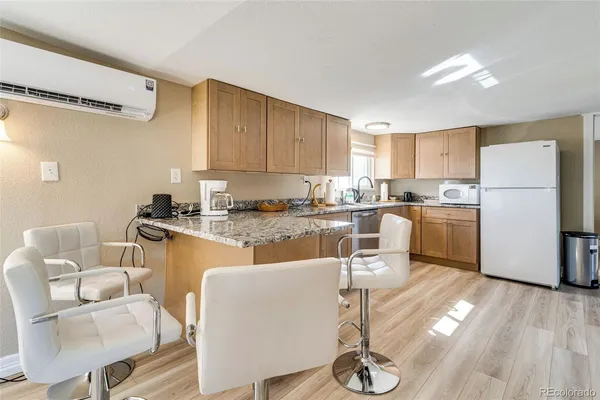 a kitchen with a refrigerator a stove a sink dishwasher and white cabinets with wooden floor