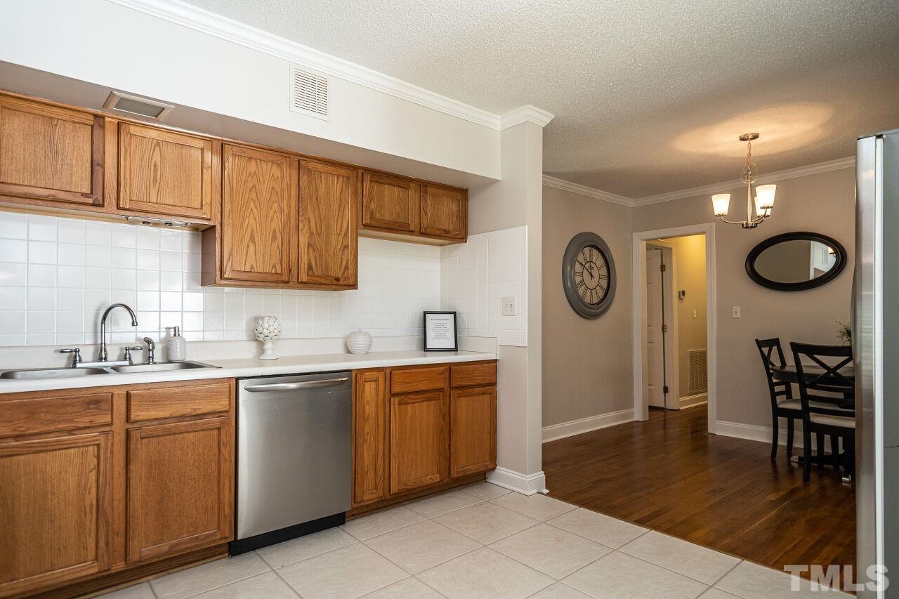 202 Purvis Street Garner, NC 27529 - Photo 11 of 29 a kitchen with stainless steel appliances granite countertop a sink a stove a refrigerator and cabinets