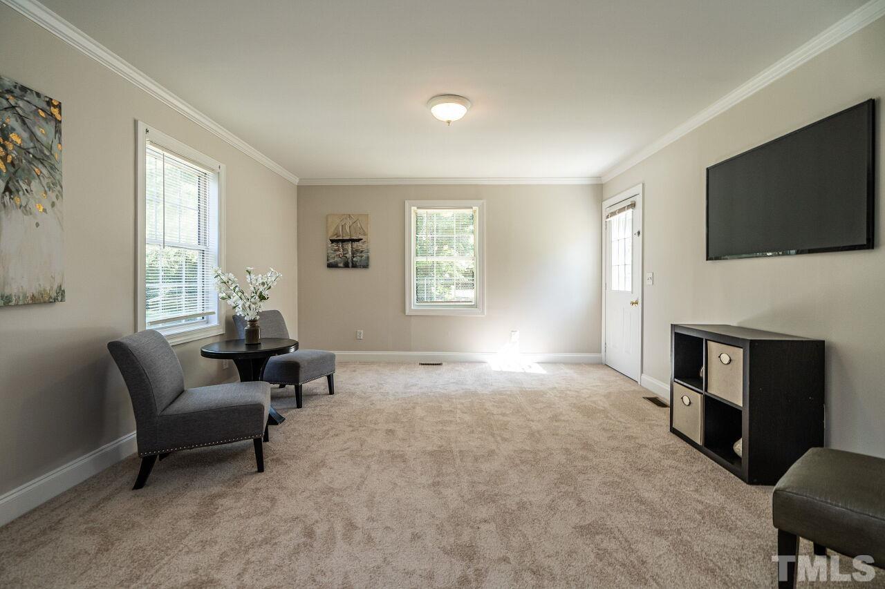202 Purvis Street Garner, NC 27529 - Photo 13 of 29 a living room with furniture a flat screen tv and a fireplace