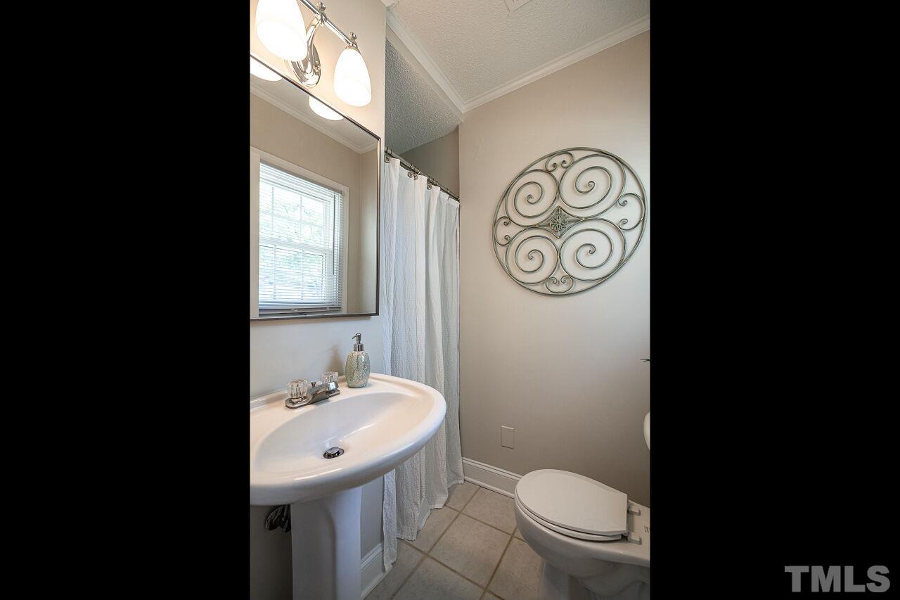 202 Purvis Street Garner, NC 27529 - Photo 15 of 29 a bathroom with a toilet sink and mirror