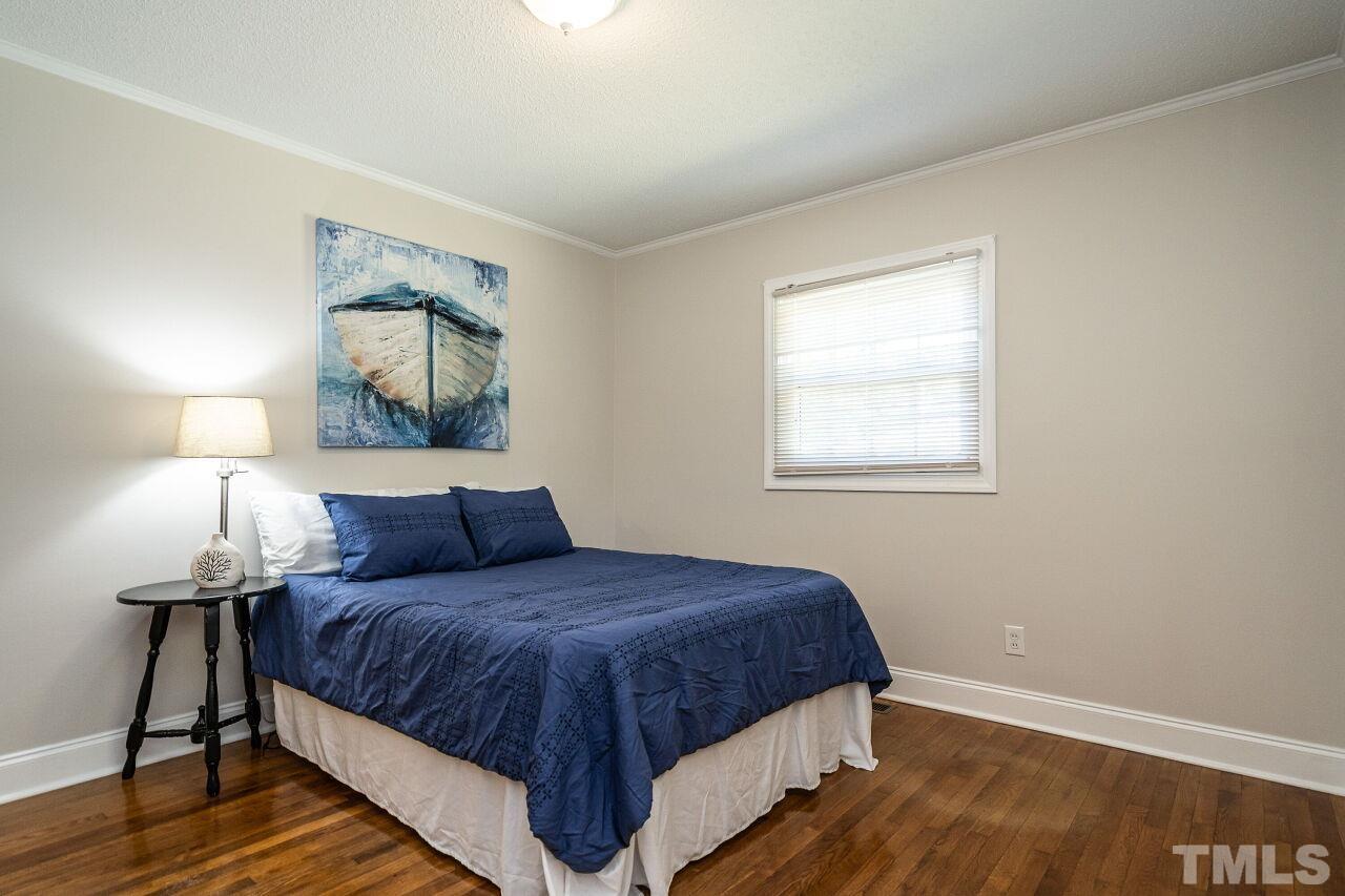 202 Purvis Street Garner, NC 27529 - Photo 18 of 29 a bedroom with a bed and wooden floor