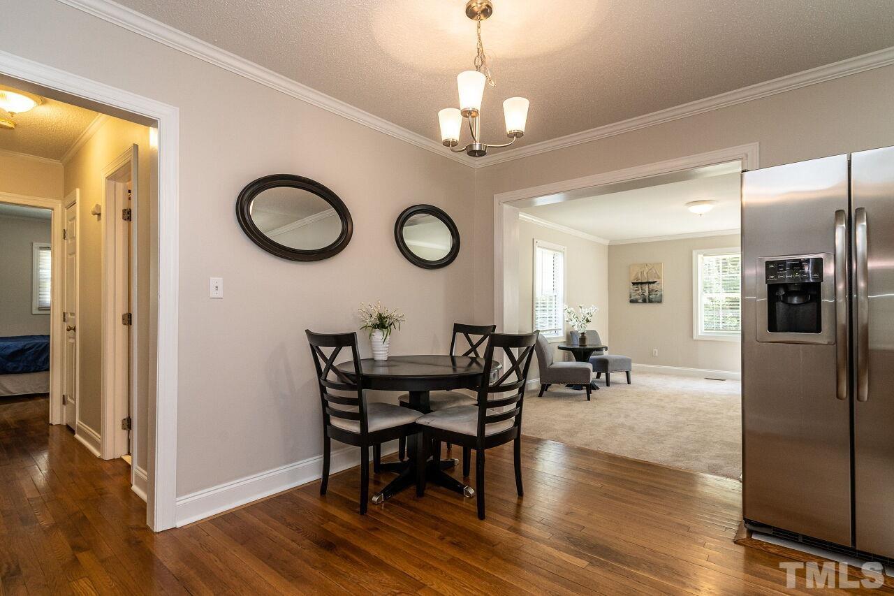 202 Purvis Street Garner, NC 27529 - Photo 7 of 29 a view of a dining room and livingroom with furniture wooden floor a chandelier
