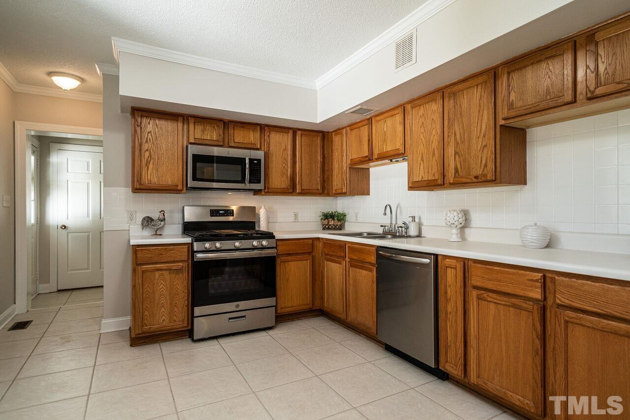 202 Purvis Street Garner, NC 27529 - Photo 8 of 29 a kitchen with stainless steel appliances granite countertop a stove top oven a sink dishwasher and a microwave oven on the blue kitchen countertops