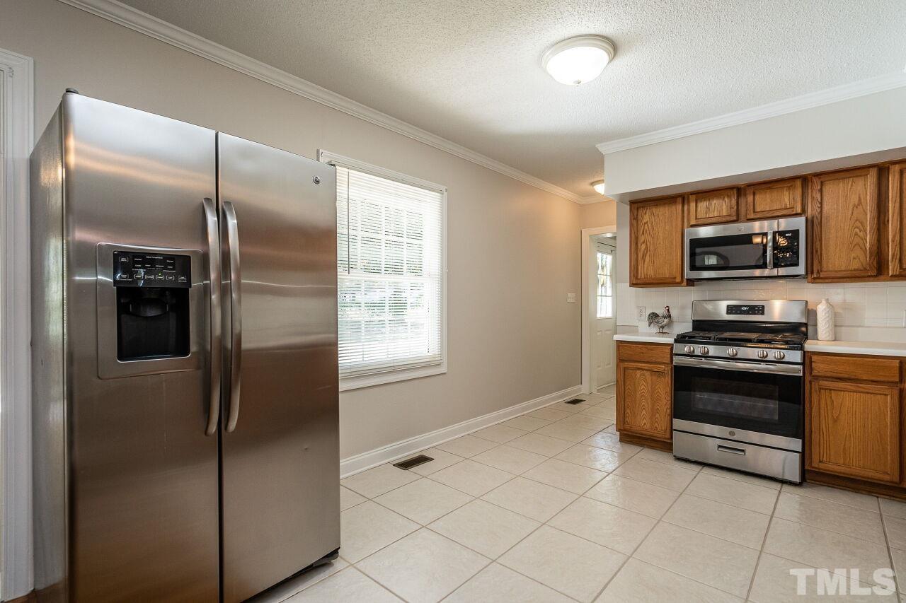 202 Purvis Street Garner, NC 27529 - Photo 10 of 29 a kitchen with stainless steel appliances granite countertop a refrigerator and a stove top oven