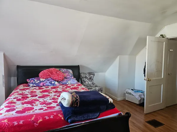 a bedroom with a bed and wooden floor