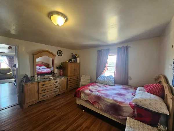 a bedroom with a bed and a dresser next to a window