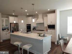 a kitchen with kitchen island a appliances dining table and chairs