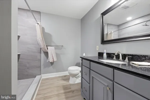 a bathroom with a granite countertop sink toilet and shower