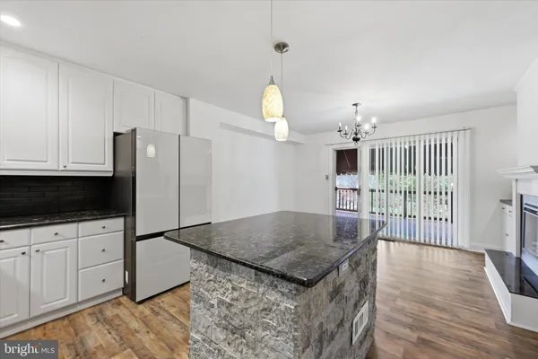a kitchen with granite countertop a stove and a wooden floors
