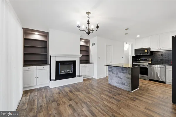a view of kitchen with granite countertop a stove top oven and refrigerator