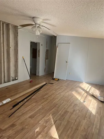 an empty room with windows and fan