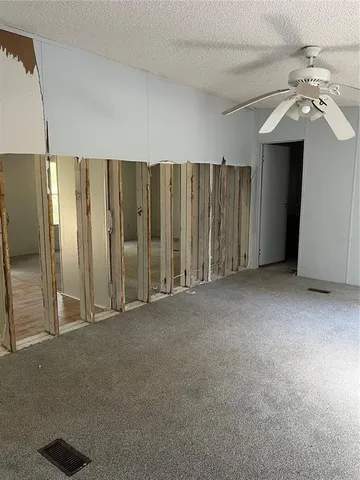 en empty room with windows and fan