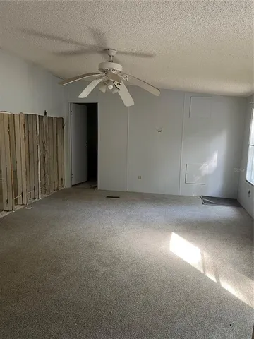 an empty room with a ceiling fan and window