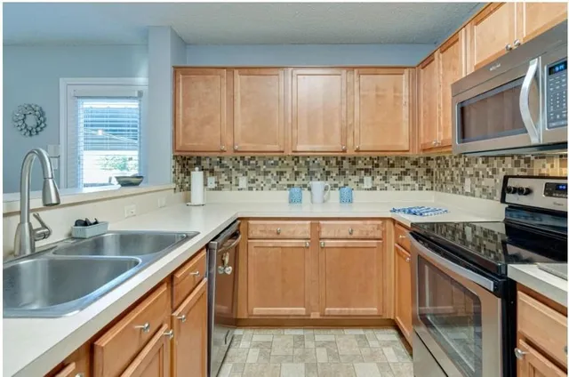 a kitchen with a sink stove top oven and cabinets