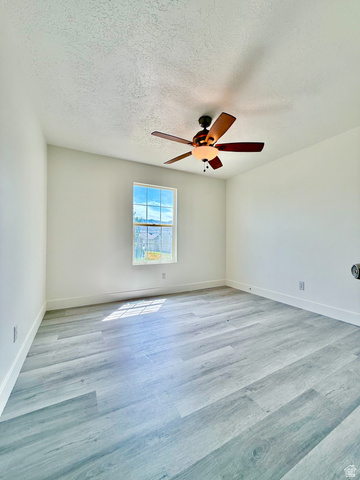 1705 80 East Tooele, UT 84074 - Photo 12 of 22 Light-filled room featuring wood-finish flooring, white baseboards, and a window providing natural illumination