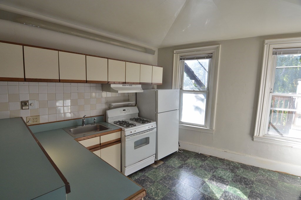 11 Savin Hill Avenue Boston, MA 02125 - Photo 13 of 40 a kitchen with a stove a sink and a window