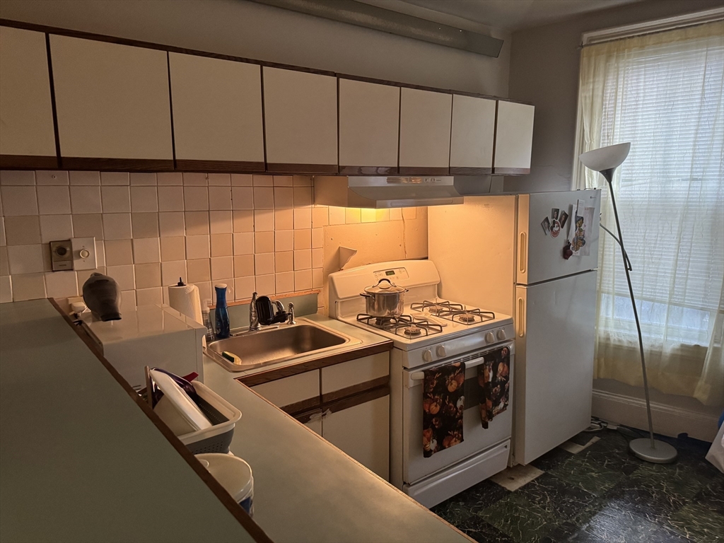11 Savin Hill Avenue Boston, MA 02125 - Photo 20 of 40 a kitchen with stainless steel appliances a stove a sink and a refrigerator