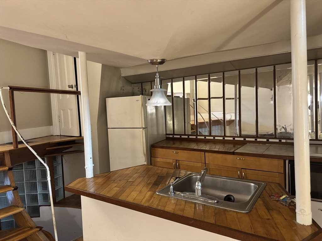 11 Savin Hill Avenue Boston, MA 02125 - Photo 27 of 40 a kitchen with a sink and a refrigerator