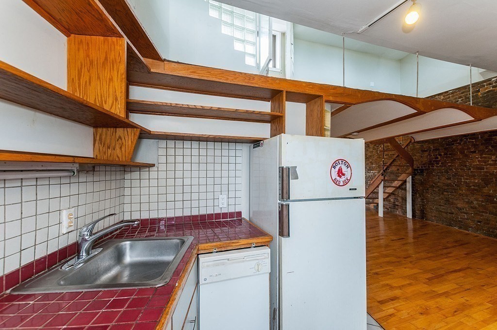 11 Savin Hill Avenue Boston, MA 02125 - Photo 8 of 40 a kitchen with a refrigerator and a sink