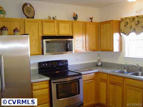 4073 Trisha Trail Midlothian, VA 23112 - Photo 2 of 4 a kitchen with stainless steel appliances granite countertop a sink a stove and a microwave
