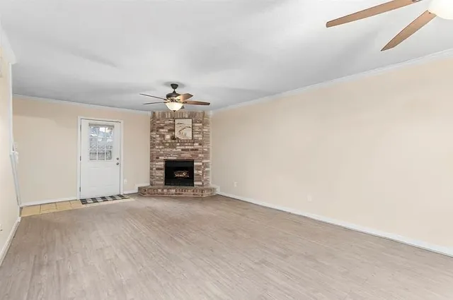 an empty room with a fireplace and chandelier