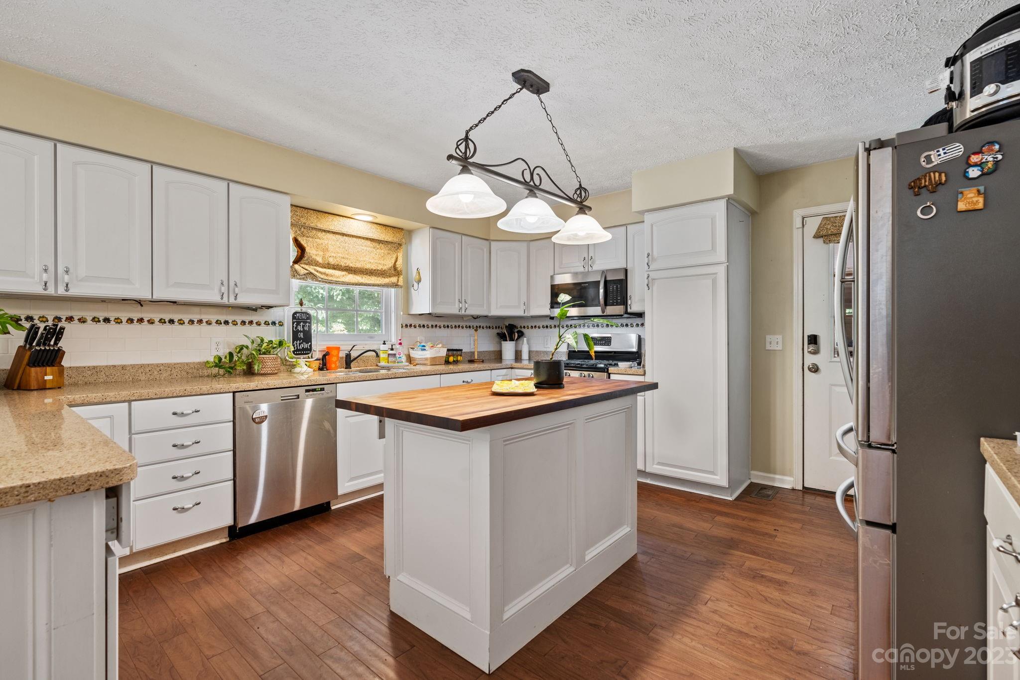 42 Bear Trail Fairview, NC 28730 - Photo 9 of 37 a kitchen with kitchen island granite countertop a sink cabinets and wooden floor