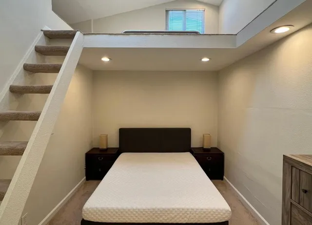 a bedroom with a bed and a black white wall