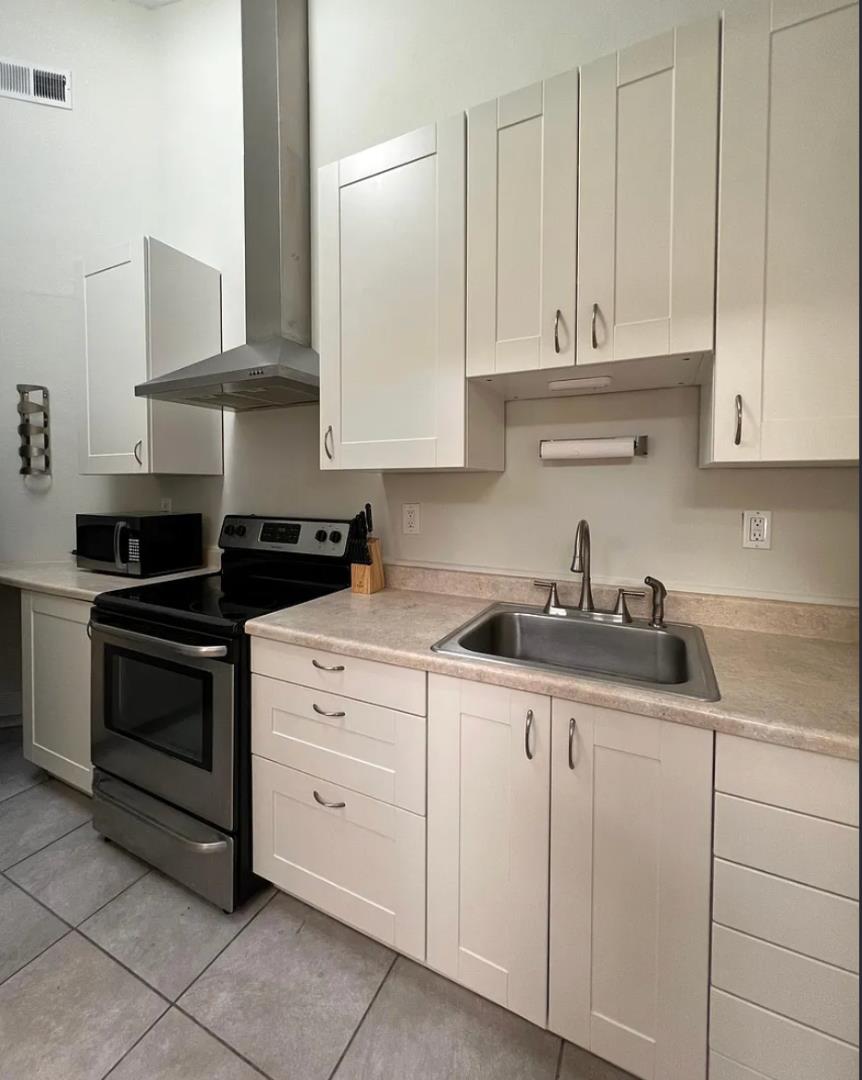 1302 Delaware Avenue Santa Cruz, CA 95060 - Photo 5 of 11 a kitchen with white cabinets and appliances