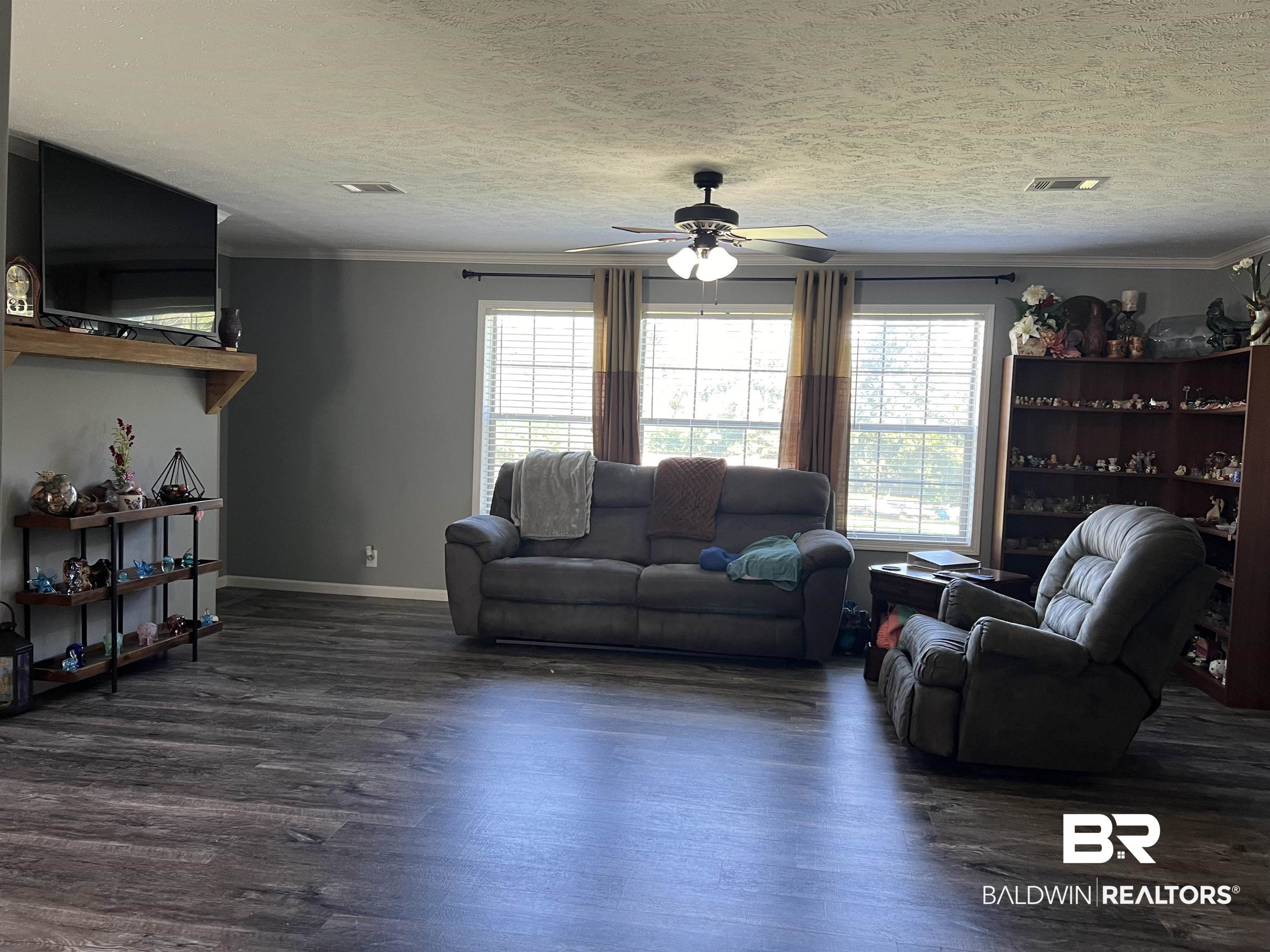 16824 Underwood Road Foley, AL 36535 - Photo 9 of 25 Living room with ceiling fan, dark hardwood / wood-style floors, and crown molding